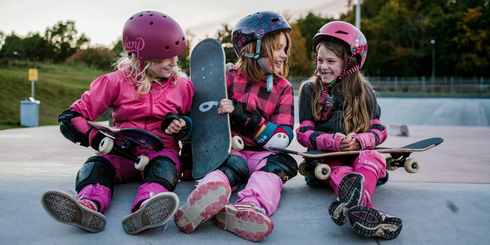 Tre flickor som tar en paus från skateboardåkningen vid skateparken i Högdalen.